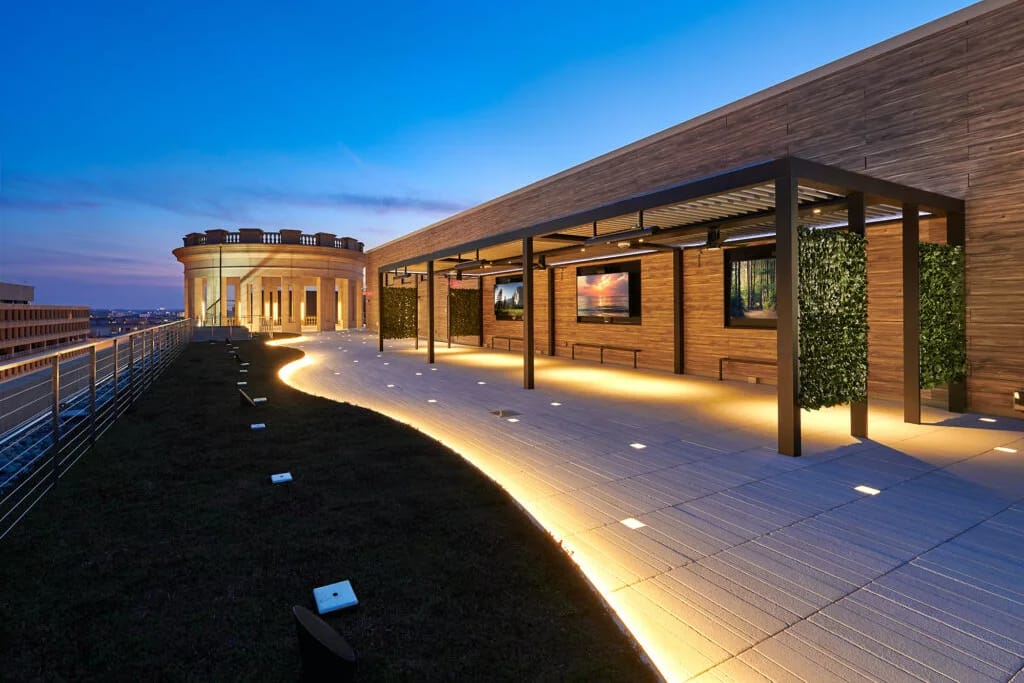 Dachterrasse an einem Holzbau in der Abenddämmerung, leuchtende Steine im Plattenbelag