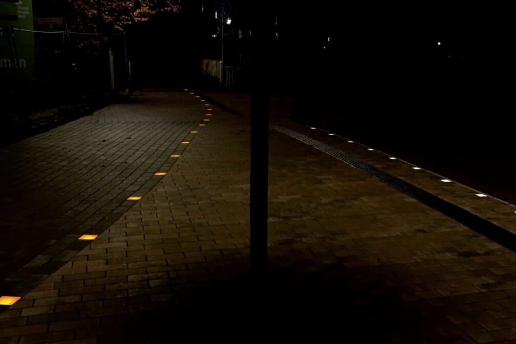 Radweg bei Nacht, leuchtende Markierungen säumen den Weg in Fahrtrichtung