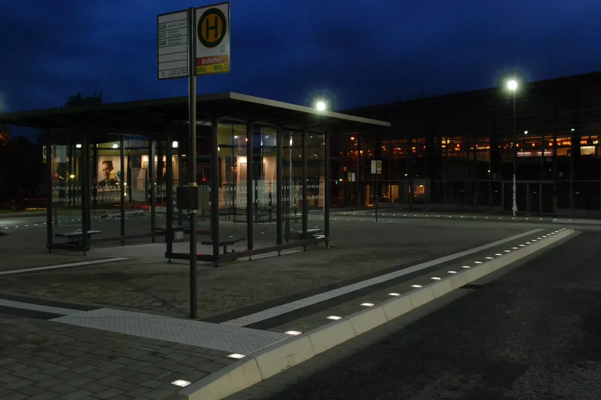 Dieselbe Haltestelle bei Nacht: die Lightstone LED-Pflastersteine markieren die Führungslinie